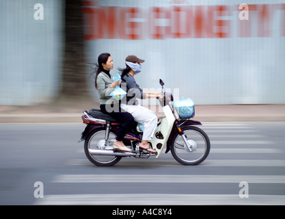 Zwei Frauen auf einem Motorroller Fahrrad reisen durch Hanoi mit Goldfischen in einem Kunststoff-Beutel, Vietnam, Asien Stockfoto