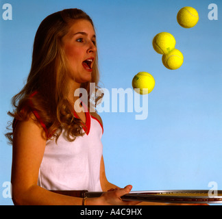 Attraktive junge Tennisspieler prallte mehrere Kugeln gleichzeitig auf ihre Tennisschläger Stockfoto