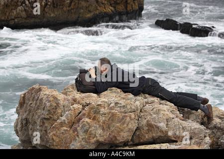 Mann liegt auf Felsen und unter Bild Stockfoto