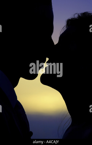 junge Paar küssen bei glühenden Sonnenuntergang Stockfoto