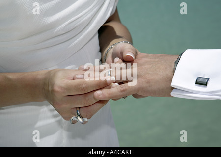 Nahaufnahme der Hand einer Frau, die Hand des Mannes Ehering aufsetzen Stockfoto