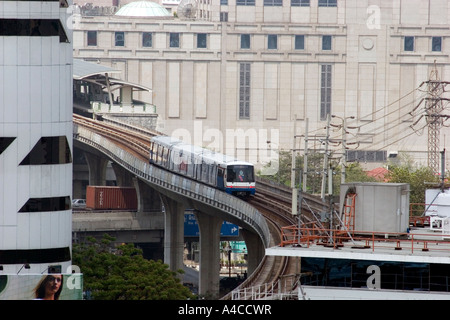 BTS Skytrain Zug Sukhumvit Station auf erhöhten gebogene Gleise über die Stadt Mitte, hinten der Shopping Mall, hinter, Bangkok, Thailand gesehen Stockfoto