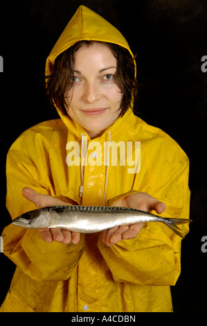 Eine Frau in gelb Oilskins mit rohem Fisch Stockfoto
