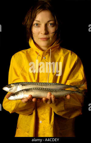 Eine Frau in gelb Oilskins mit rohem Fisch Stockfoto