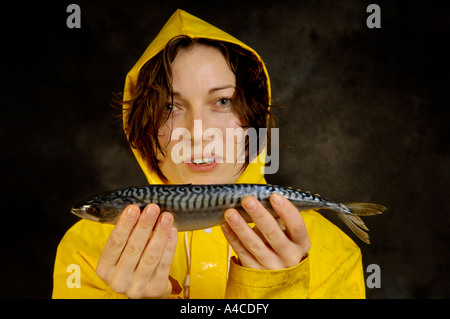 Eine Frau in gelb Oilskins mit rohem Fisch Stockfoto