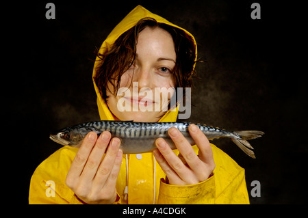 Eine Frau in gelb Oilskins mit rohem Fisch Stockfoto