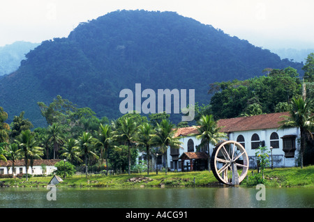 in der Nähe von Angra Dos Reis, Brasilien. Typische alte Fazenda Ranch-Haus mit Palmen und Berge im Hintergrund. Stockfoto