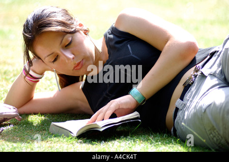 Lizenzfreie kostenlose Foto britischen College-Studentin in London Park UK entspannen lesen und überarbeiten. Stockfoto