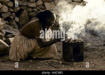 DEN TÄGLICHEN KAMPF UMS ESSEN MIT DEM KOMMEN EINER NEUEN HUNGERSNOT MESHAL DORF, MAI 1991. LETENK'IEL BEREITET EIN FEUER ZUM KOCHEN. Stockfoto