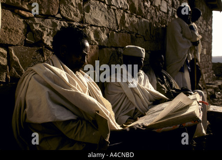 DEN TÄGLICHEN KAMPF UMS FÜR LEBENSMITTEL MIT DEM KOMMEN EINER NEUEN HUNGERSNOT MESHAL DORF, MAI 1991. GEBREMARIAM GOYTEM LESEN BIBEL. Stockfoto