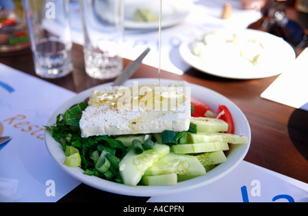 Öl auf griechischer Salat gegossen Stockfoto