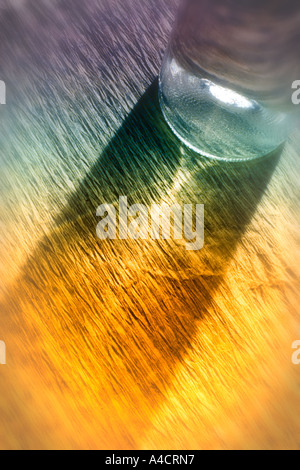 Transparente Glas weiß Weinflasche und Schatten vom Licht, das durch das Glas. Strukturiertes Papierhintergrund. Bild unscharf aro Stockfoto