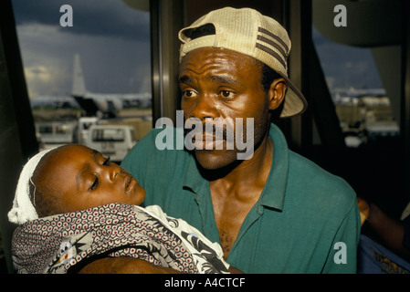 Kigali, Ruanda, April 1994; Ein ausländischer Staatsangehöriger und seine Tochter, verwundet durch Granatsplitter, warten in Kigali Flughafen warten auf ein UN-Flugzeug evakuiert werden. Stockfoto