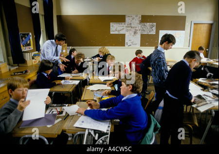 Ein Lehrer hilft den Schülern während des Unterrichts in einer gemischten Gesamtschule. Stockfoto