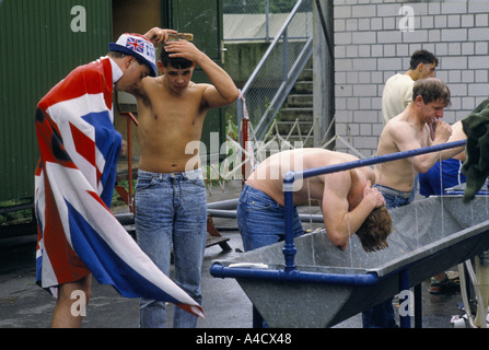 JUNGE MÄNNLICHE ENGLAND-UNTERSTÜTZER, DIE WÄHREND DER EUROPAMEISTERSCHAFT 1988 HAARE UND ZÄHNE AN WASCHBECKEN IM FREIEN WASCHEN, Stockfoto