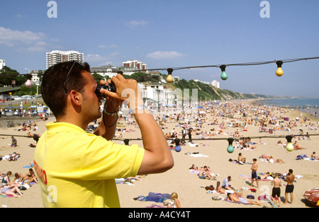 UK Dorset Bournemouth Rettungsschwimmer Badegäste durch ein Fernglas beobachten Stockfoto