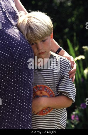 Schwangere Mutter mit Arm um den kleinen Jungen, neun Monate schwanger Stockfoto