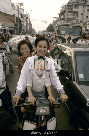 Vietnam Saigon zwei Frauen und ein Kind auf einem Roller während der Rush hour Stockfoto