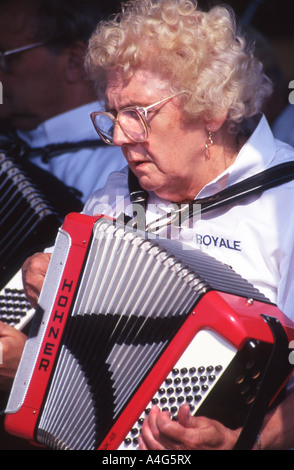 Frau in der Band spielt Akkordeon im Freien. Stockfoto
