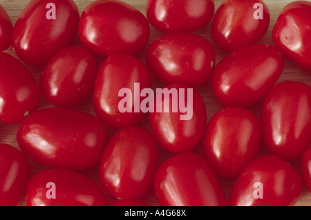 Solanum lycopersicum syn Lycopersicon esculentum 'Santa' (Tomate) kleine längliche rote Tomaten auf dem Tisch. Stockfoto