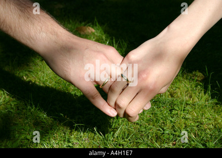 wahre Liebe und Zweisamkeit Mann und Frau, die Hand in Hand mit goldenen Engagement Trauringe Stockfoto