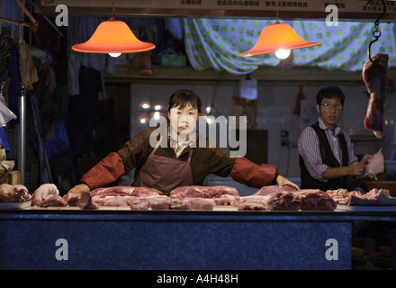 CHINA SHANGHAI männliche und weibliche Metzger arbeiten bei einer late-Night-Fleisch-Markt in Shanghai Nachbarschaft Stockfoto