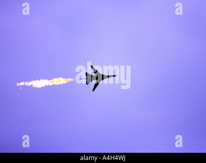 Der RAAF F-111 JET entlädt Treibstoff, während er über einen dramatischen violetten Himmel fährt und die Leistung der militärischen Luftfahrt und die Luftdynamik zeigt. Stockfoto