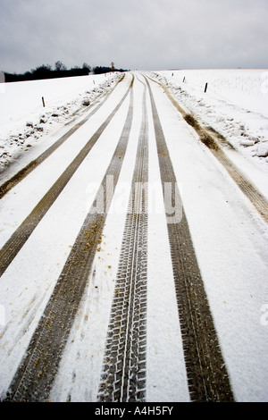 Reifenspuren auf verschneiten Landstraße Stockfoto