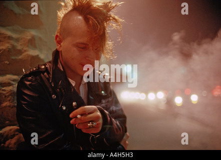 Junger Mann mit Mohawk Haarschnitt raucht eine Zigarette vor eine alternative Disco Club in Jacksonville Florida USA Stockfoto