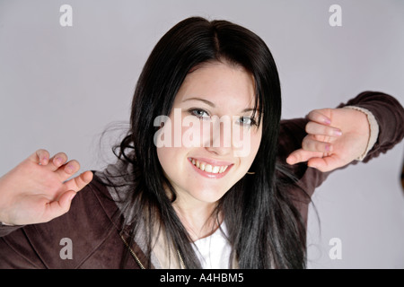 Junge Mädchen im Alter von 16 mit schwarzen Haaren nach oben sehen Sie zuversichtlich Arme ausgestreckt Stockfoto