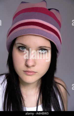 Junge Mädchen im Alter von 16 mit schwarzen Haare nach oben sicher aussehen, schöne Augen und großen gestreiften Colouful Hut lila oder lila und rosa Stockfoto