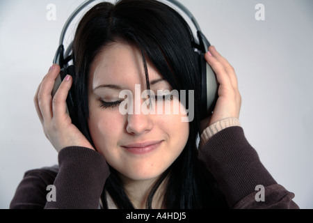 Junge Frau mit Kopfhörern auf Musikgenuss mit Augen geschlossen Stockfoto