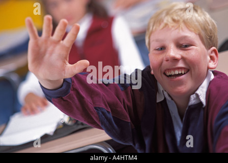 Kaukasische männlichen Studenten, die Hand in der Mittelschule Klasse heben Stockfoto