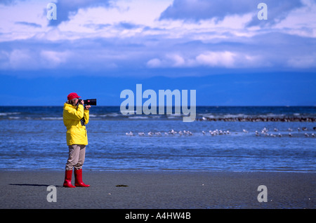 Fotograf mit dem Fotografieren mit Teleobjektiv vor der Kamera, auf der Westküste von Vancouver Island, BC, British Columbia, Kanada Stockfoto