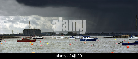 Ferner Regen über AKW Bradwell bewegt sich in Richtung Boote vertäut am West Mersea in der Nähe von Colchester Essex Stockfoto