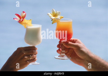 Paar auf Urlaub Toasten mit bunten tropischen drinks Stockfoto