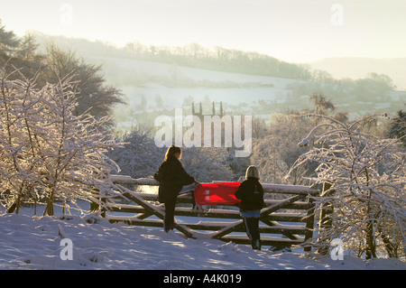 KINDER BEGEBEN SIE SICH AUF EINEN SCHLITTEN AUSFLUG IM SCHNEE IN DER NÄHE VON WOTTON UNTER EDGE GLOUCESTERSHIRE Stockfoto