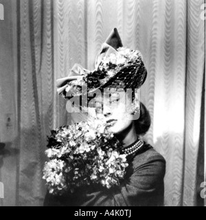 Frau mit Hut mit Schleier, mit einem Strauß Blumen, Paris, 1943. Artist: Unbekannt Stockfoto