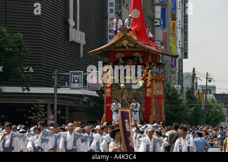 Eine alte Matsuri Festival Schwimmer steht im Gegensatz zu den modernen Gebäuden des Kyoto-Protokolls während der Gion-Parade Stockfoto