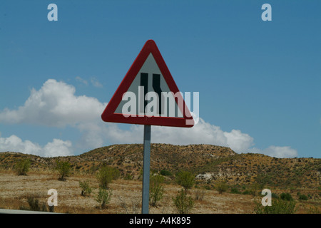 Straße Hinweisschild Verengung Straße mit Landschaft und Himmel im Hintergrund Stockfoto