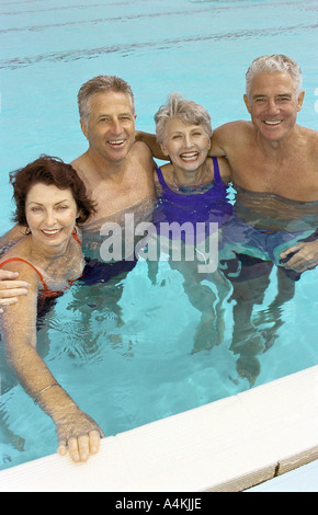 Zwei ältere Ehepaare stehen im Schwimmbad Stockfoto