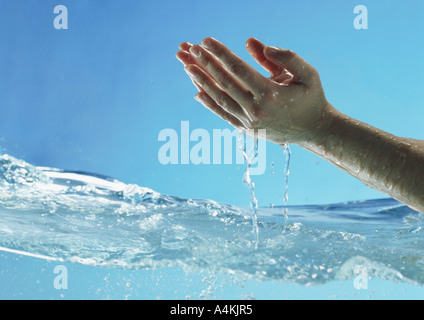 Die Haende und Frau tropft über Wasser Oberfläche, Seitenansicht Stockfoto