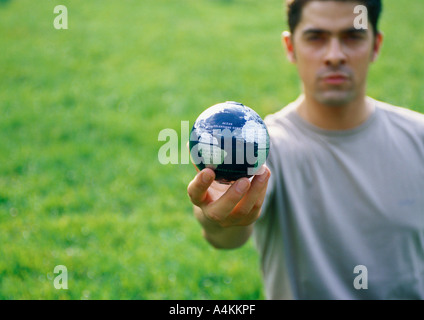 Mann hält kleine Weltkugel Stockfoto