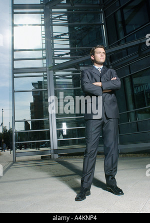 Geschäftsmann Gelenkarme, Gebäude im Hintergrund Stockfoto