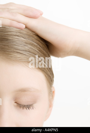 Frau mit den Händen auf den Kopf und die Augen geschlossen, Nahaufnahme Stockfoto