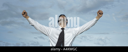 Mann vor Himmel mit gestreckten Arme, Hüfte aufwärts, Vorderansicht Stockfoto