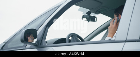 Frau im Auto reden über Handy, Reflexion im Spiegel der hinteren Ansicht Stockfoto