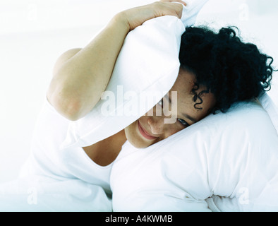 Frau im Bett Kopf mit Kissen zu bedecken Stockfoto