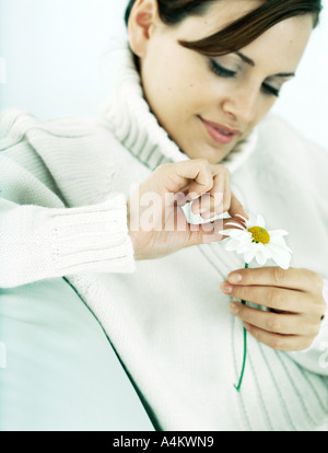 Frau zupfen Blütenblätter von Daisy, blickte, Nahaufnahme Stockfoto