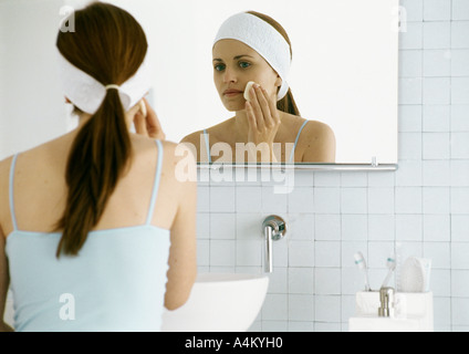 Frau waschen Gesicht vor Spiegel Stockfoto